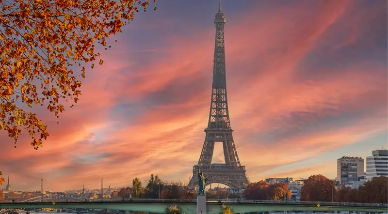 The Eiffel Tower against a pink autumn sunset above the Seine
